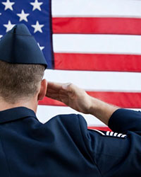 veteran saluting in front of American flag